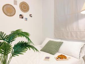 a bed with a plate of food and a plant at Sha lala stay in Seoul