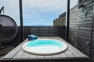 a bath tub sitting on top of a balcony at 伊豆高原 記念日を祝う宿 自然家 Haco しぜんや ハコ in Ito