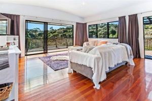a bedroom with a bed and large windows at Paradise Near Palm Beach in Palm Beach