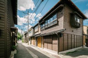 un antiguo edificio de madera al lado de una calle en Tokisora Machiya House, en Kanazawa