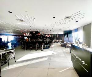 a restaurant with a bar with tables and chairs at Novotel Residential Tower at Acqua Private Residences Mandaluyong - Makati in Manila