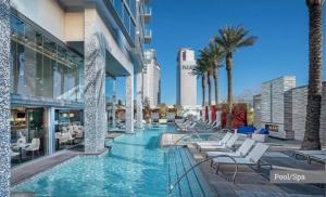 a pool with chairs and palm trees in a building at 37th FLOOR STUDIO STRIP VIEW Palm Place Resort in Las Vegas