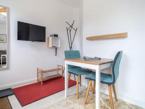 a room with a table and two chairs and a tv at UNS MUUSLOCK in Ahrenshoop