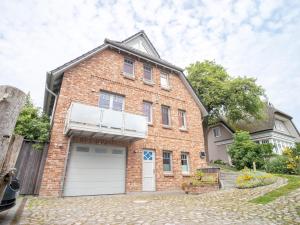 a brick house with a white garage at UNS MUUSLOCK in Ahrenshoop