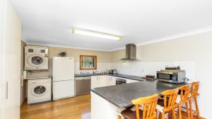 a kitchen with a refrigerator and a counter with chairs at Barkeldine Farm Country Retreat in Bucca-Wauka