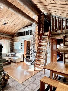 a living room with a spiral staircase in a log cabin at Villa Saarua by the Slopes Ski in, Family & Bike Park, hike trails, National Park, WiFi - Lapland Villas in Ruka +116 photos