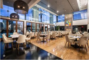 a restaurant with tables and chairs and windows at 37th FLOOR STUDIO STRIP VIEW Palm Place Resort in Las Vegas