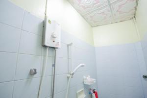 a shower in a bathroom with white tiles at Tin home in Ban Kohong +21 photos
