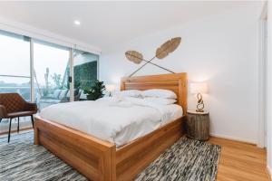 a bedroom with a large bed and a large window at Lakeside 3-Bed Apartment with Jacuzzi in Belconnen +18 photos