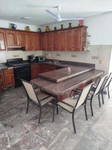 una cucina con un grande tavolo e sedie in legno di Hermosa casa con Alberca Marina Brisas Villa San Gabriel ad Acapulco