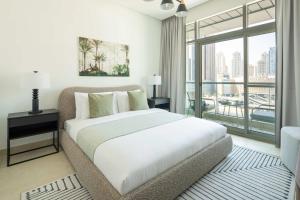 een slaapkamer met een groot bed en een groot raam bij Frank Porter - Madina Tower in Dubai