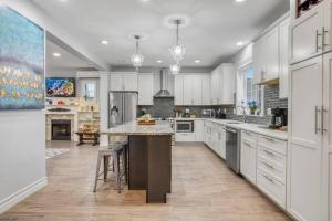 una grande cucina con mobili bianchi e una grande isola di Historic remodeled home in Laurelhurst Portland a Portland