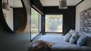 a bedroom with a bed with a large window at Callubri Station - The River Suite in Cajildry