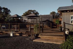a deck with tables and umbrellas on a house at Callubri Station - The River Suite in Cajildry