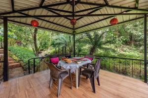 un patio avec une table et des chaises sur une terrasse dans l'établissement CosmicStays Windchime Homestay at Mulshi, à Mulshi