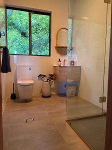 Un baño con inodoro y ducha de cristal. en Mountain hideaway Blue Mountains, en Kurrajong 15 fotos más