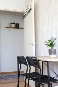 mesa de comedor con 2 sillas y maceta en Heim Apartments, en Seinäjoki