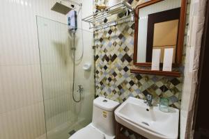美岸Vigan Traversa Hotel的配有马桶、水槽和淋浴的浴室