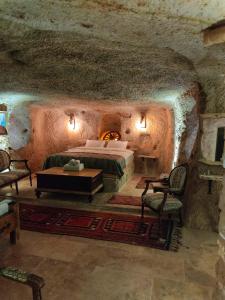 a bedroom with a bed in a stone cave at Lubberona Cave Cappadocia in Nar