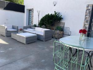 Un patio con sofás y una mesa de cristal y sillas. en Casa Rural Miraelrio, en Corral Rubio