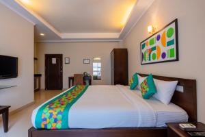 a bedroom with a large bed and a television at Treebo Ivory White Inn in Bengaluru +30 photos