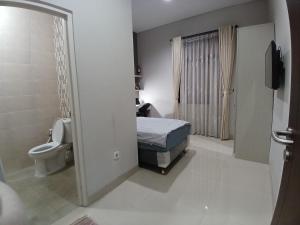 a bathroom with a bed and a toilet in a room at Oren Stayz ICE BSD in Pagedangan +16 photos