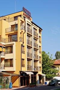un edificio amarillo con un cartel de hotel en Family Hotel Ramira, en Kyustendil
