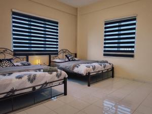 een slaapkamer met twee bedden en twee ramen bij Casuarina Lot-1103 Malacca in Melaka +22 foto's