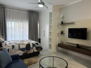 a bedroom with a bed and a flat screen tv at Cozy-corner in Gaborone