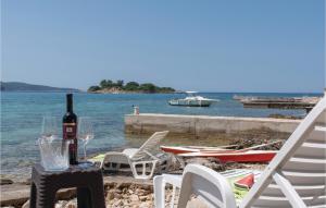 ヴェラ・ルカにあるBeautiful Home In Gradina With Kitchenのビーチのテーブル(ワイン1本付)と椅子