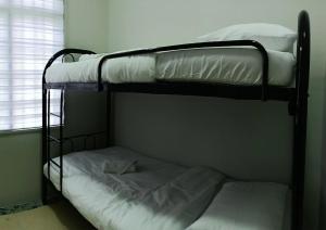 quelques lits superposés dans une chambre dans l'établissement Caza Cottage Terengganu, à Kampong Gong Badak