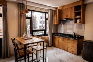 uma cozinha com armários de madeira e uma mesa e cadeiras de madeira em Sinpa Home Pilachhen em Pātan