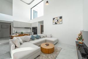 a living room with a white couch and a table at Peaceful Paradise in Saiyuan Villa V147 in Ban Saiyuan (1)