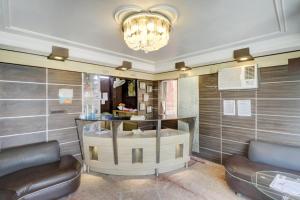 a room with a salon with two chairs and a chandelier at Hotel O Mukut Mahal in Meerut