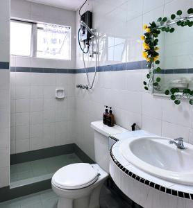 een witte badkamer met een toilet en een wastafel bij Casuarina Lot-1103 Malacca in Melaka