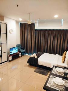 a bedroom with a bed and a tv in it at Cozy Haven Perfect Studio Getaway in Petaling Jaya