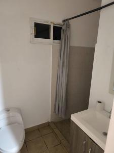a small bathroom with a toilet and a sink at Casa Tezal Alberca in Cabo San Lucas