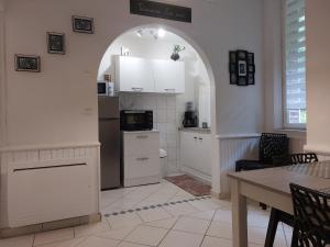 a kitchen with an archway with a refrigerator and a table at LE CISE EAU À bois in Le Bois de Cise