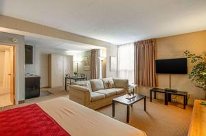 a hotel room with a couch and a television at Econo Lodge Metro in Arlington