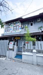 un edificio bianco con un cancello davanti di OstiC House a Yogyakarta