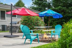a patio with two chairs and a table and an umbrella at TRAVERSE CITY RETREAT with Hot tub Games Pets in Traverse City