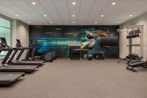 - une salle de sport avec plusieurs tapis de course et un grand écran dans l'établissement Home2 Suites By Hilton Ankeny, à Ankeny