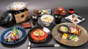 a table topped with plates of food and chopsticks at Kyoto no Yado Gion no Tsuki in Kyoto