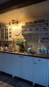 a kitchen with white cabinets and a counter top at Domek PoZiomek in Życiny +18 photos