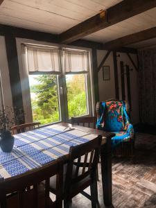 a dining room with a table and a chair and a window at Domek PoZiomek in Życiny