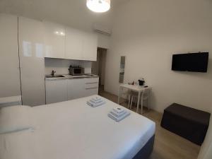 a white room with a bed and a kitchen at Assago Forum 12 in Assago