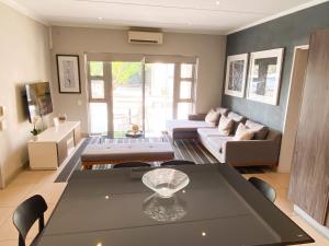 a living room with a table and a couch at Simler at Sandton in Johannesburg +6 photos