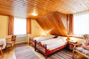 a bedroom with two beds and a wooden ceiling at Landgasthof Haueis in Marktleugast