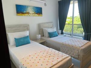 two beds in a room with a balcony at Sandy Bliss in Nilaveli +40 photos