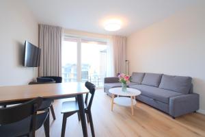 una sala de estar con un sofá y una mesa en Laguna Beskidów Resort - Apartament A96, en Zarzecze